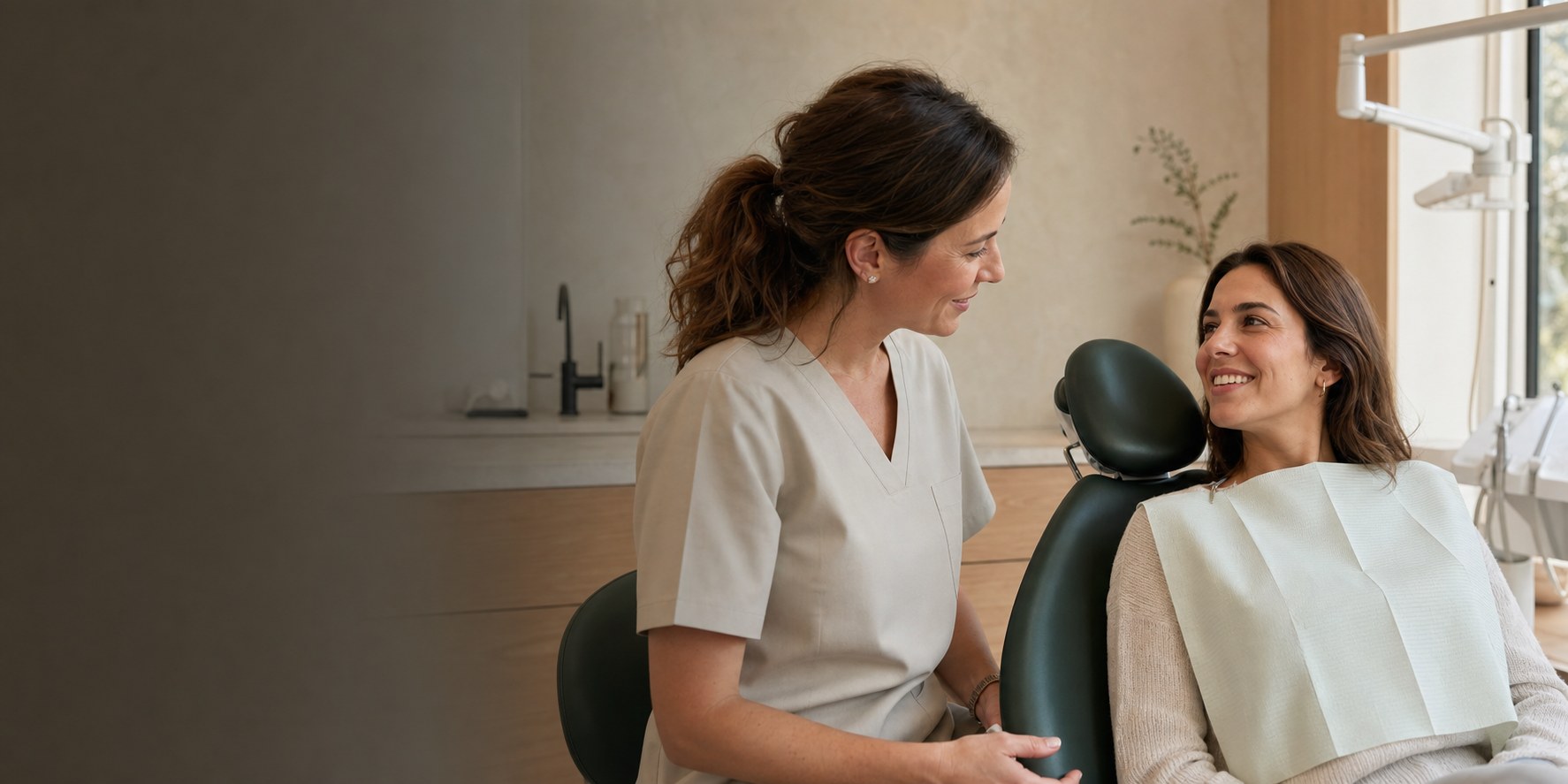 Doctora dental conversando con una paciente sonriente en una clínica cálida